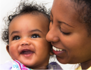 Smiling African American woman holding baby girl